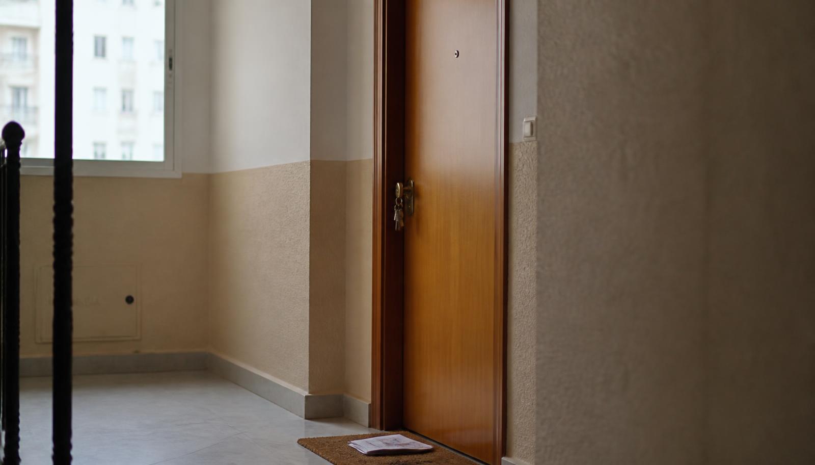 Puerta de una vivienda con las llaves en la cerradura tras un acuerdo de salida